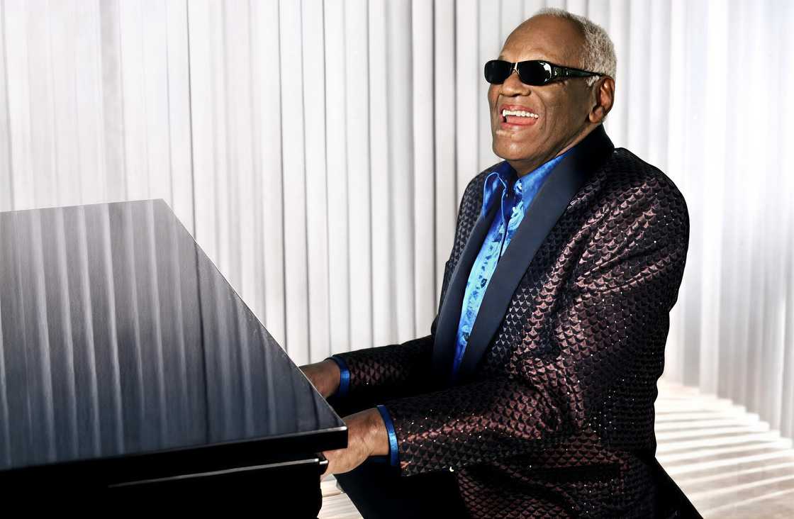Ray Charles plays the piano and sings