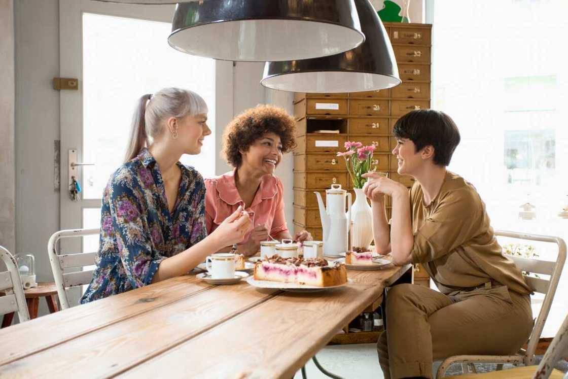 Three ladies sits enjoying a meal Three ladies sits enjoying a meal