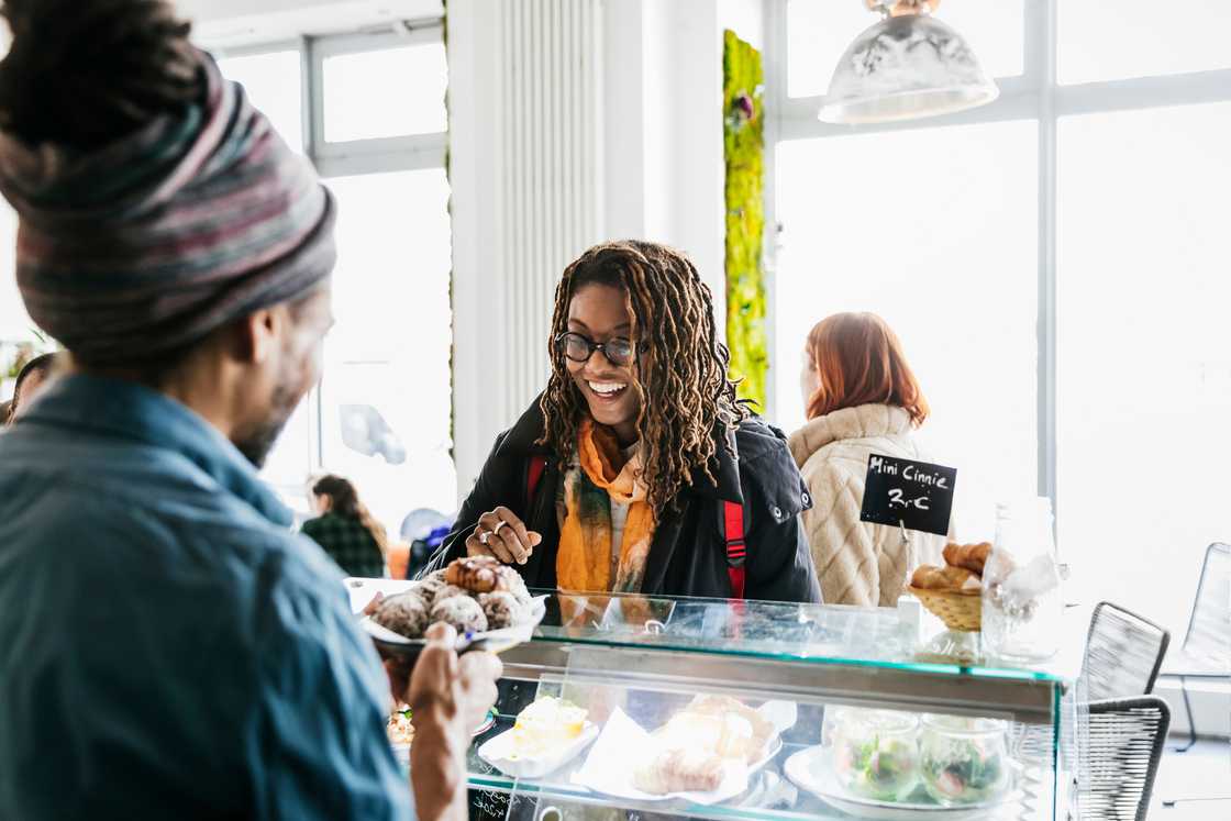 A woman and a man share a light laugh at the counter. A woman and a man share a light laugh at the counter.