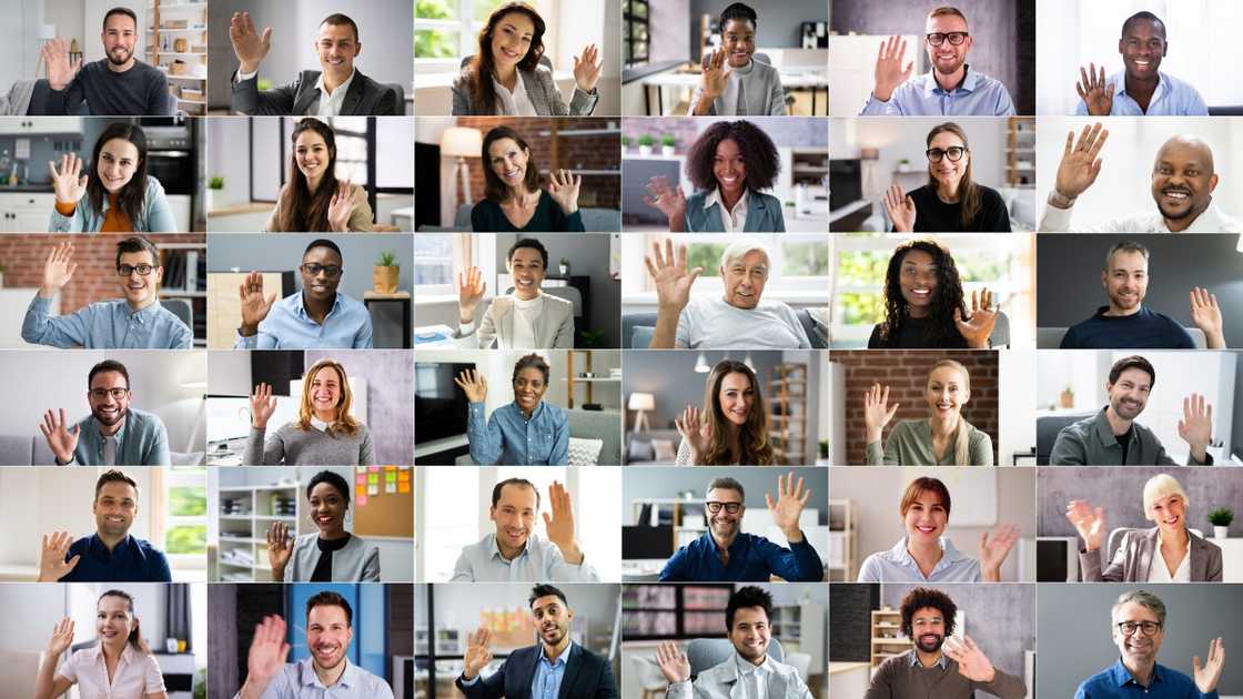 A large group of people wave during a Zoom call. A large group of people wave during a Zoom call.