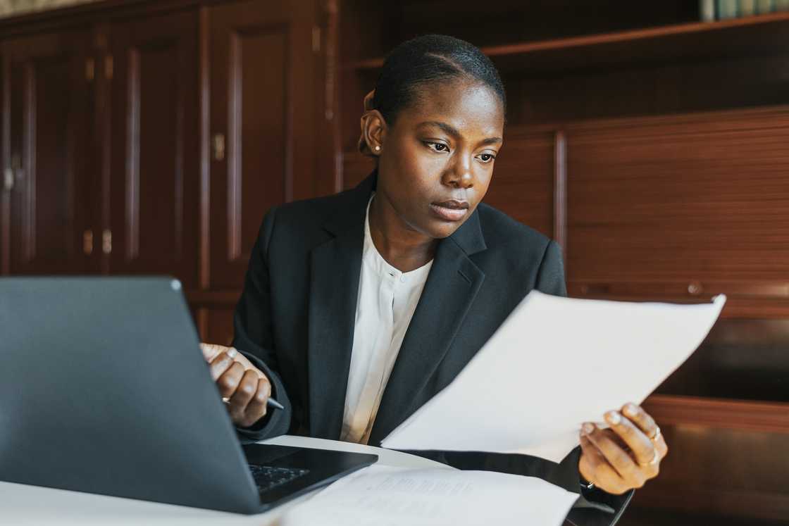 A lady compares her reports A lady compares her reports