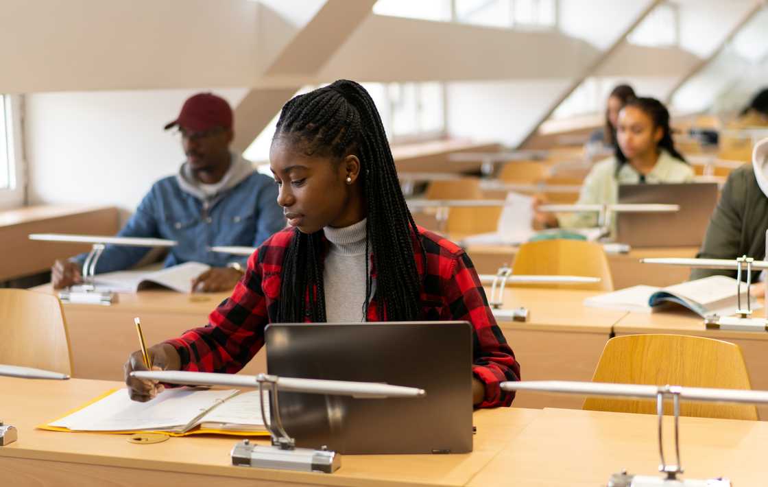 Male and female college students study in a lecture room.