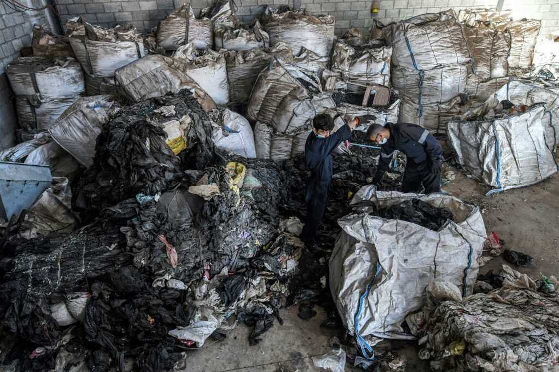 Workers sort through sacks of plastic waste at a workshop of the Egyptian startup company TileGreen Workers sort through sacks of plastic waste at a workshop of the Egyptian startup company TileGreen
