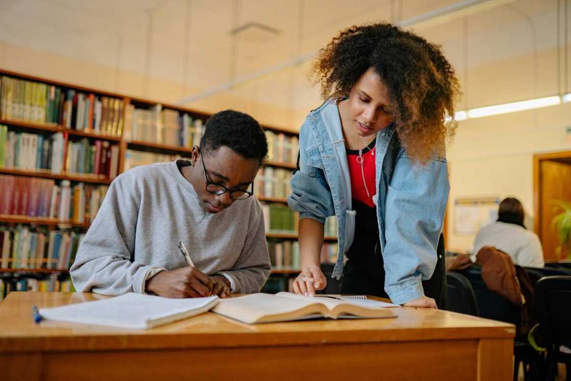 Young man and woman studying inside the library