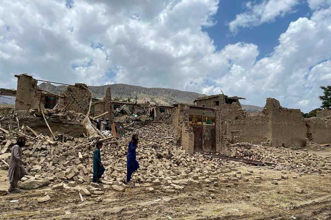 People in Afghanistan's Ghurza village walk dazed through the rubble of houses destroyed in a 5.9-magnitude earthquake that struck Bermal district, Paktika province, as desperate rescuers struggle to reach cut-off areas in the country's east