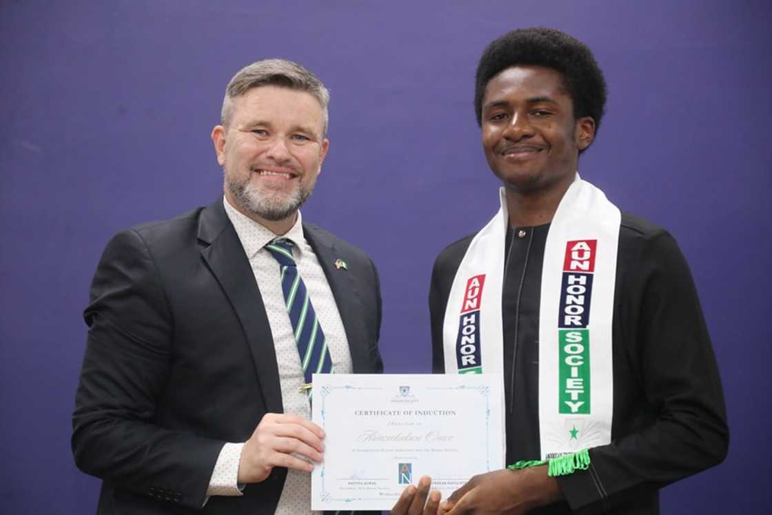 American University of Nigeria Vice Chancellor handing a certificate of induction to a student