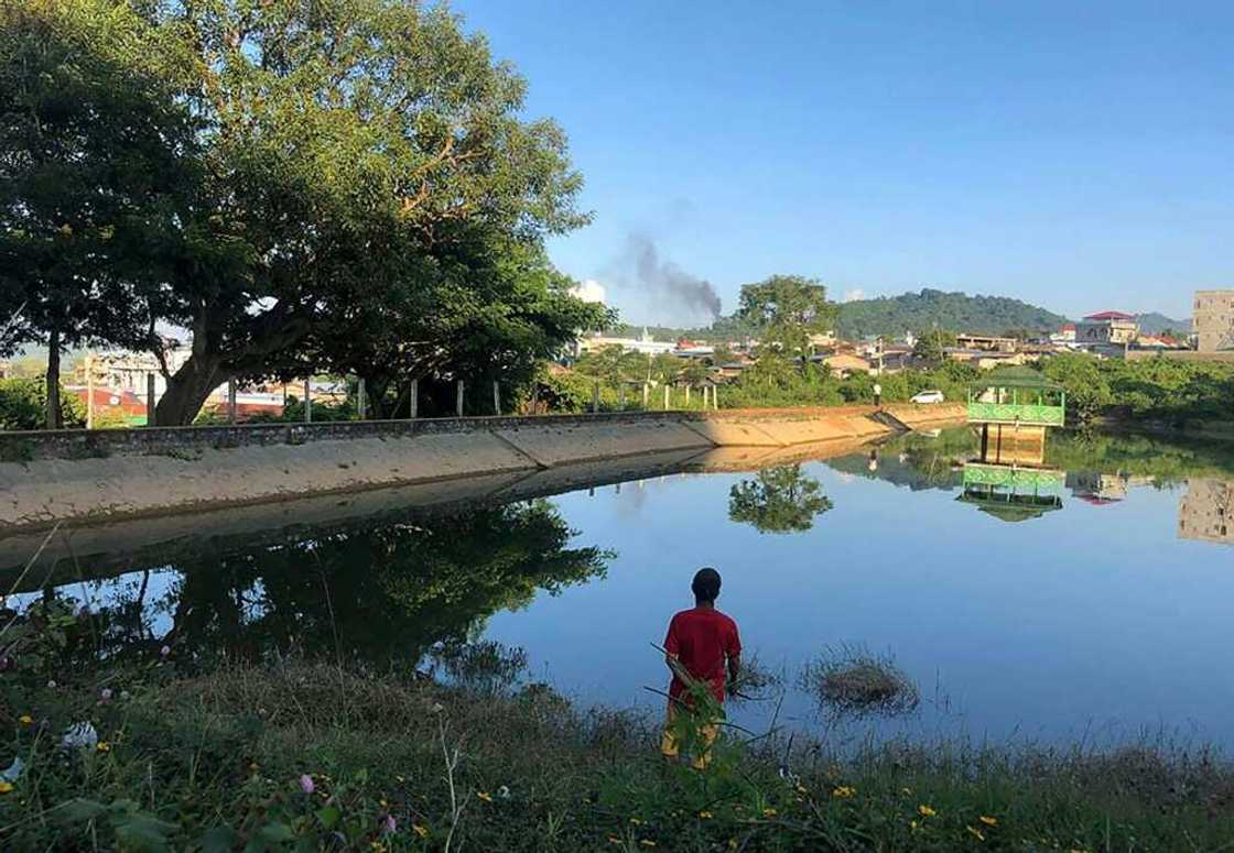 Smoke rises from the direction of a Myanmar military base in Lashio township in northern Shan State, where residents say fighting is driving up prices