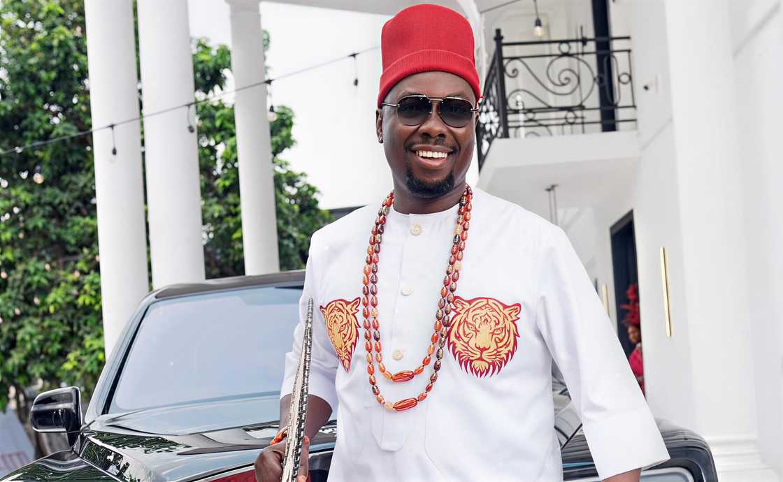 Obi Cubana wearing a traditional white outfit and traditional Igbo red cap