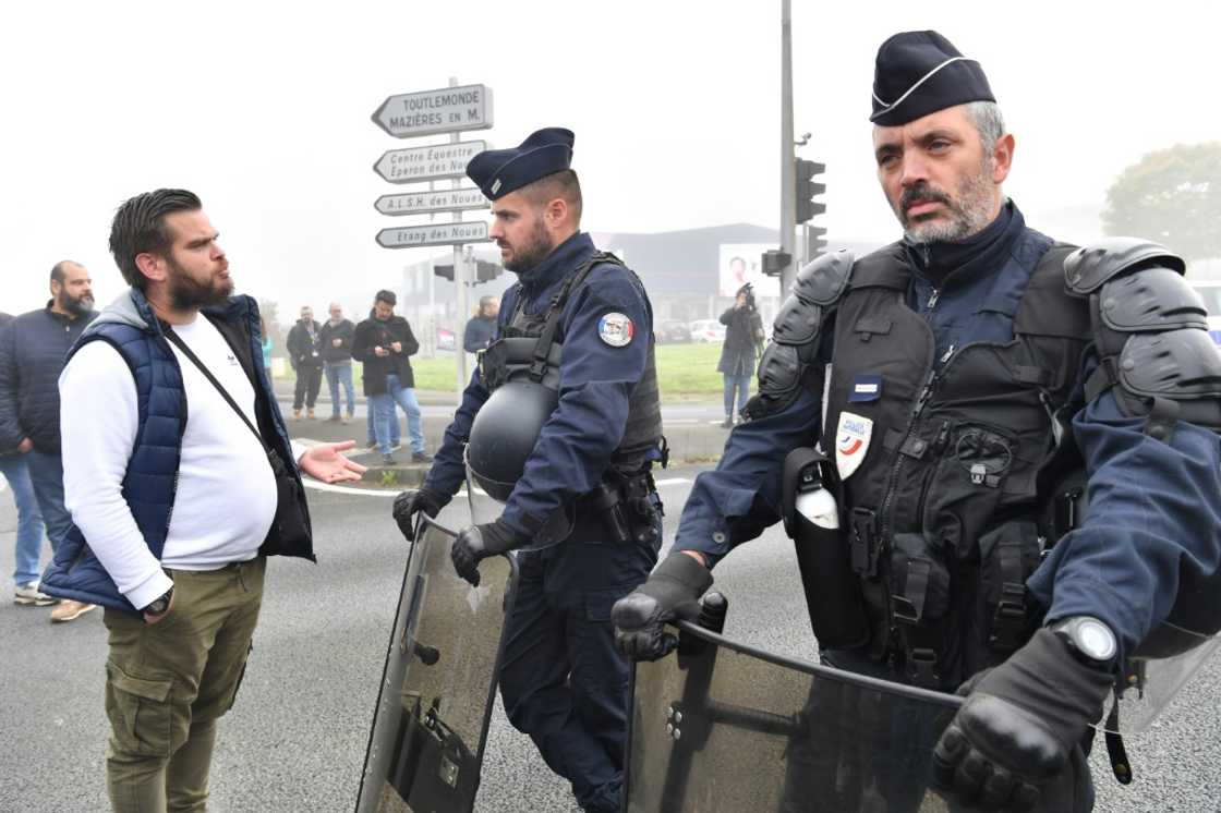 A worker talks to police officers during a demonstation at the Michelin plant in Cholet, western France A worker talks to police officers during a demonstation at the Michelin plant in Cholet, western France
