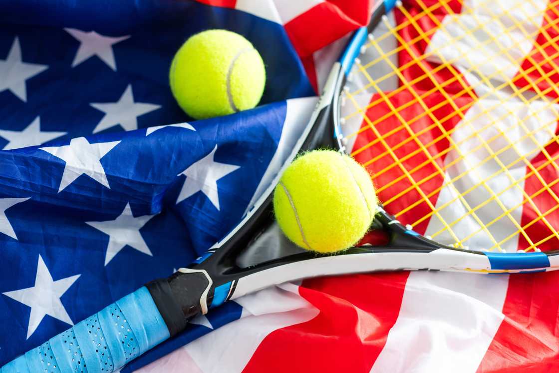 A tennis racquet with a tennis ball on the USA flag