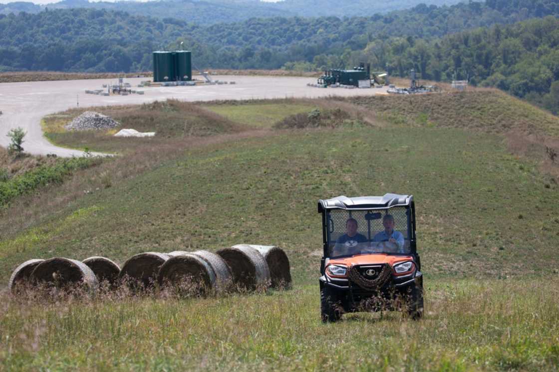 Diana Petrie, left, and her father George Wherry drive through hay fields after giving a tour of the natural gas well site on their farm in West Bethlehem Township, in Washington County, Pennsylvania