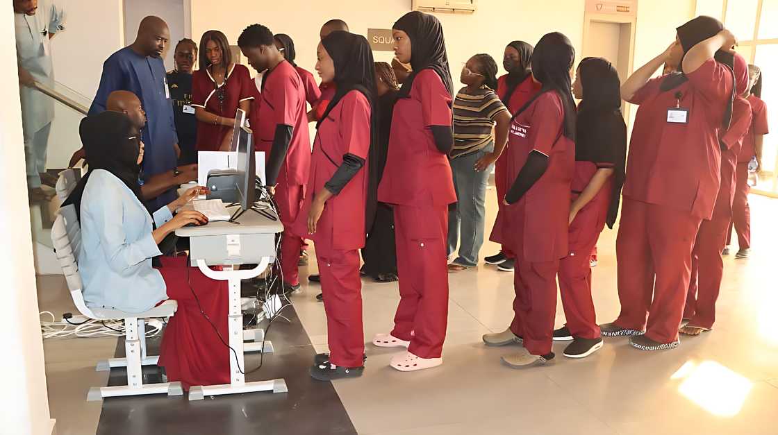 Baze medical sciences students line up at a desk Baze medical sciences students line up at a desk