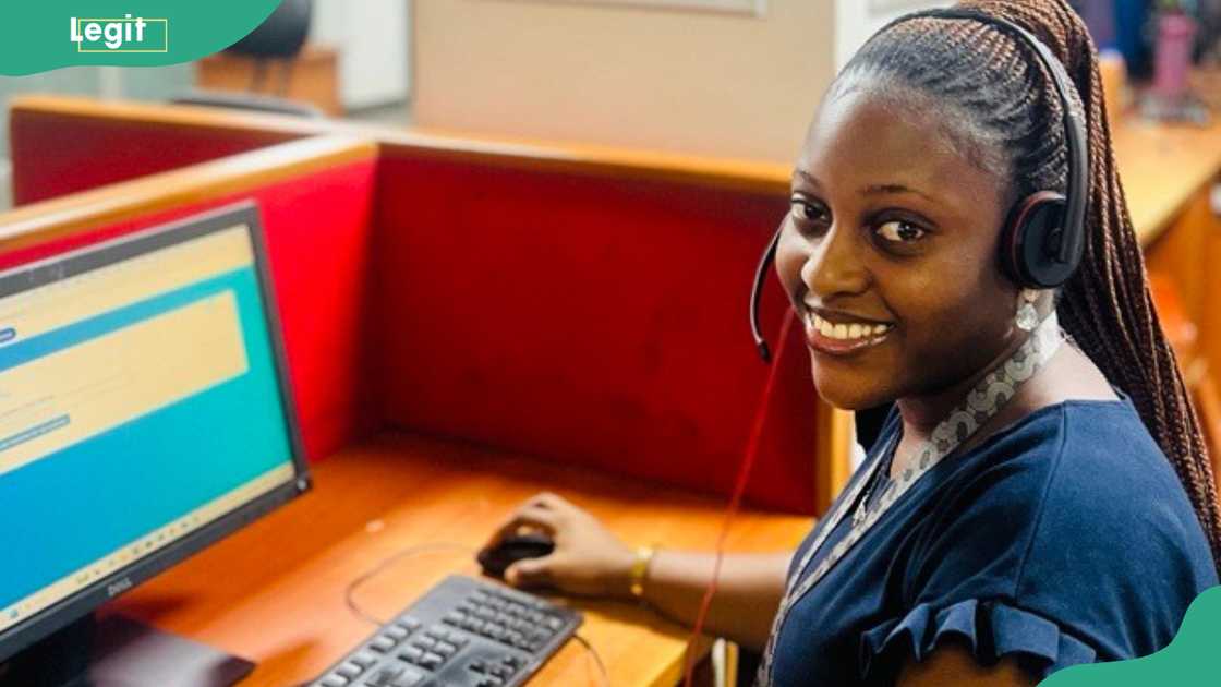 A woman smiles as she uses a desktop computer A woman smiles as she uses a desktop computer