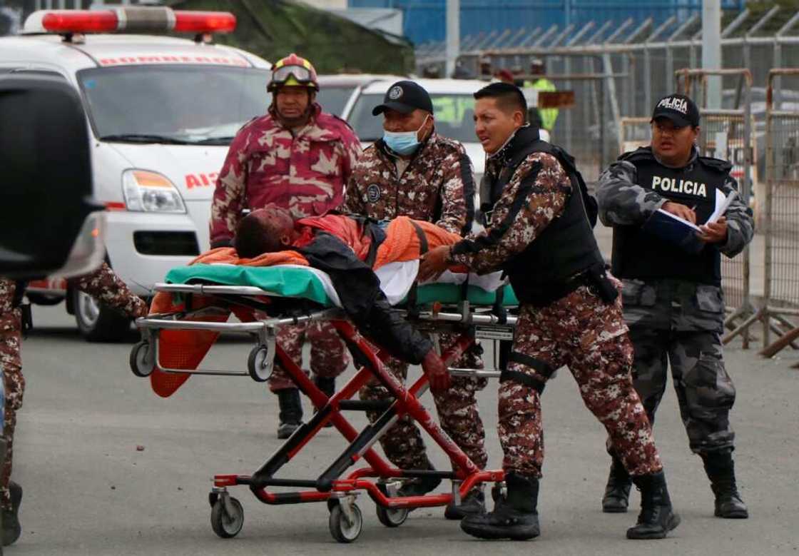 Prison guards evacuate an injured prisoner following fresh clashes at the Regional Sierra Centro Norte Cotopaxi prison, in Latacunga, Ecuador