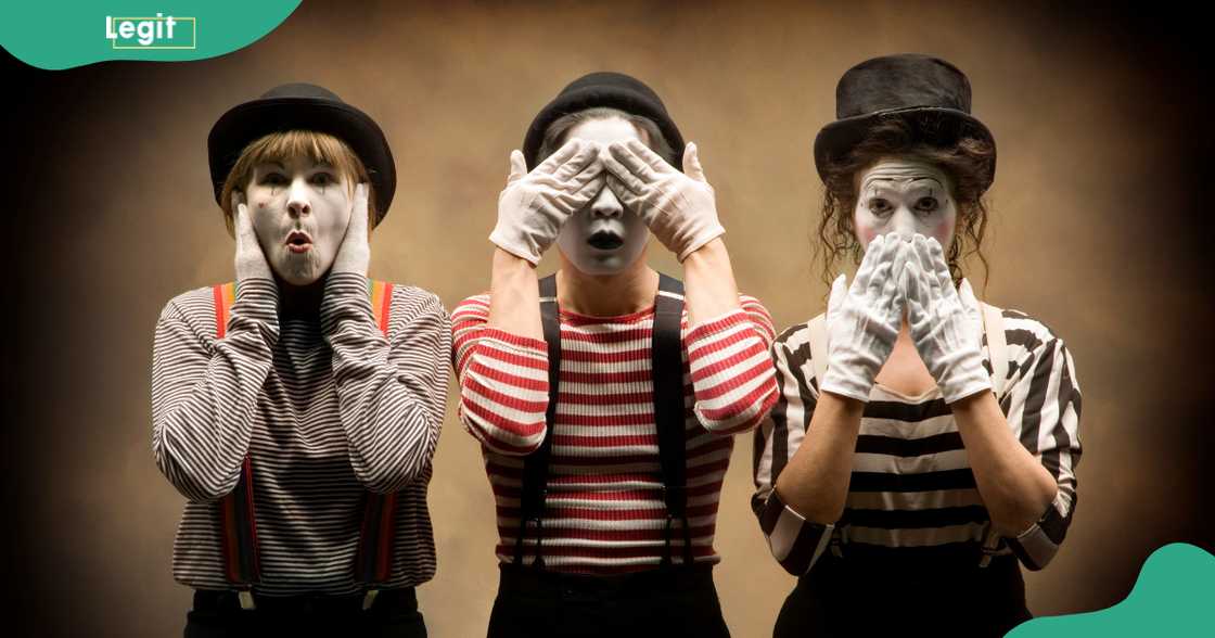 Three mimes acting out 'Hear No Evil, See No Evil, Speak No Evil'.