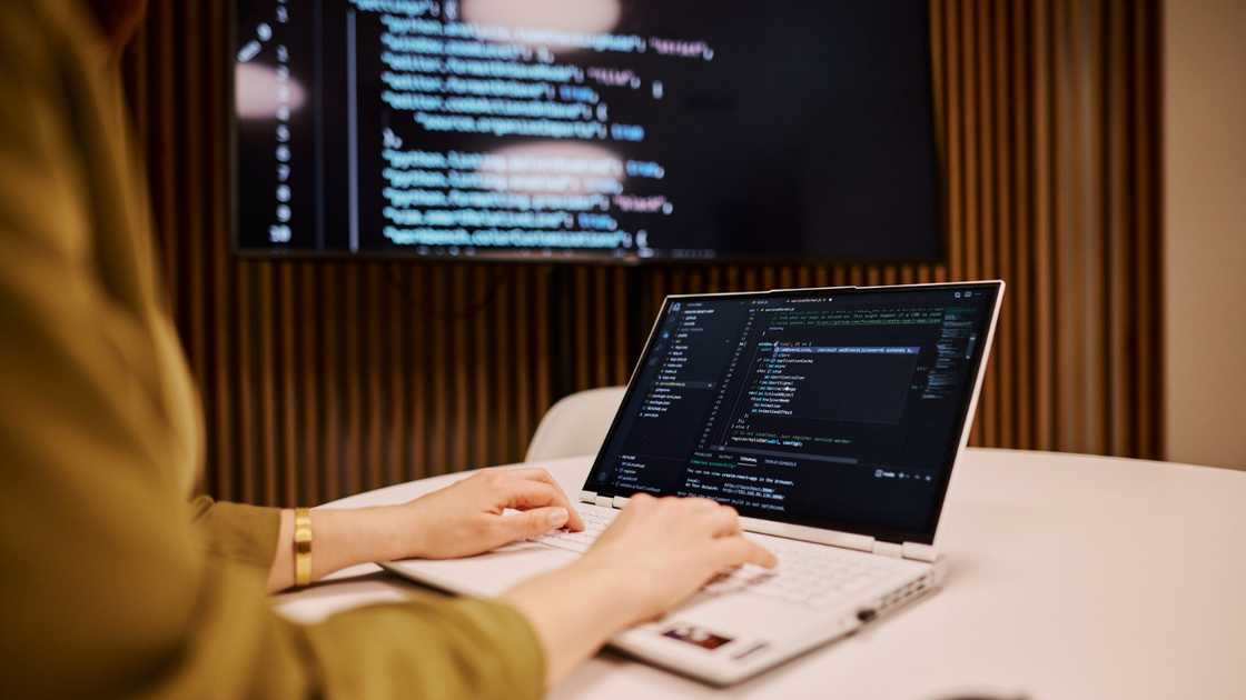 Computer programmer writing code on a laptop Computer programmer writing code on a laptop