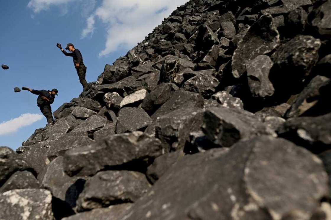 Workers sort coal near a coal mine in Datong, China's northern Shanxi province on November 2, 2021