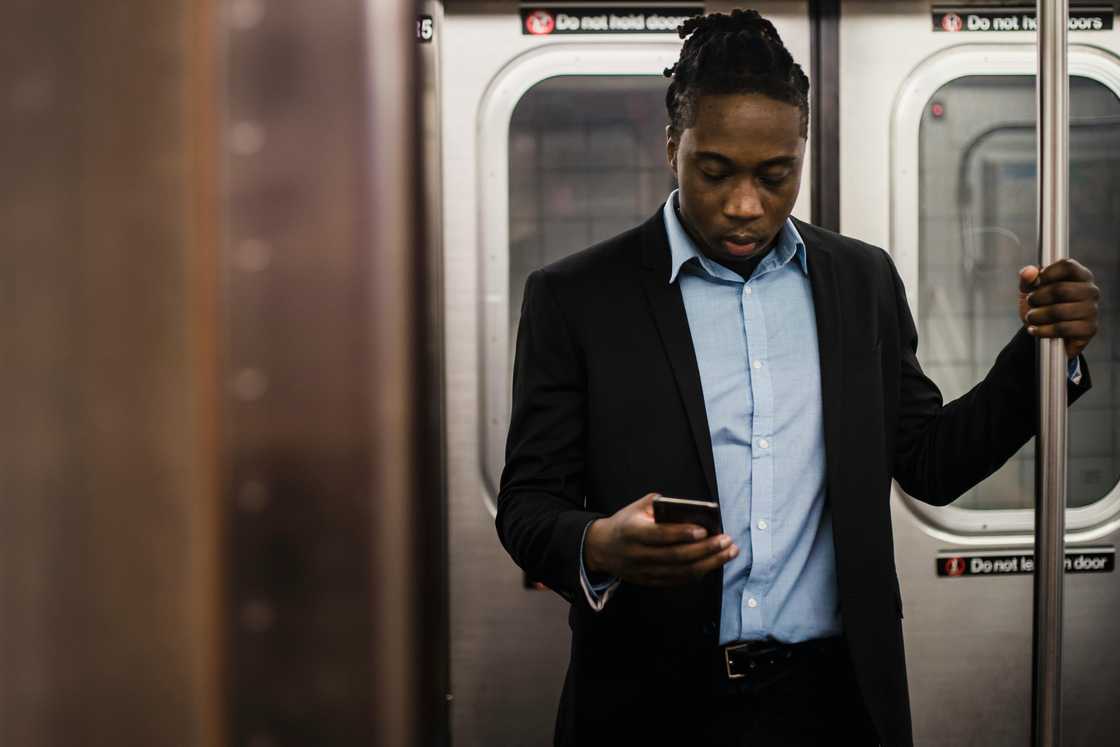 A man using a smartphone on a train