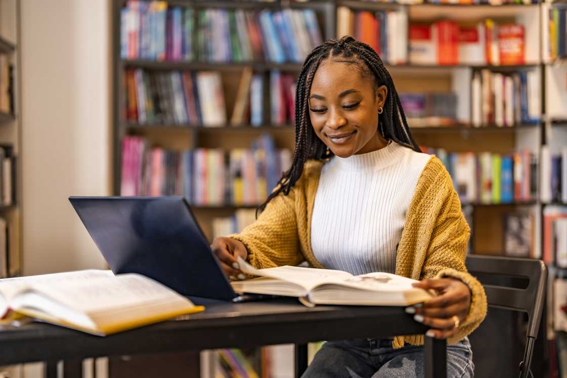 A female university student using a laptop while studying