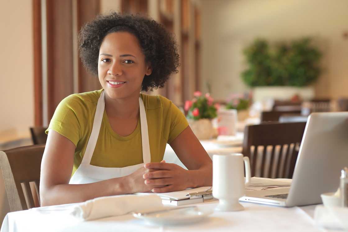 African American woman sitting at a restaurant table African American woman sitting at a restaurant table