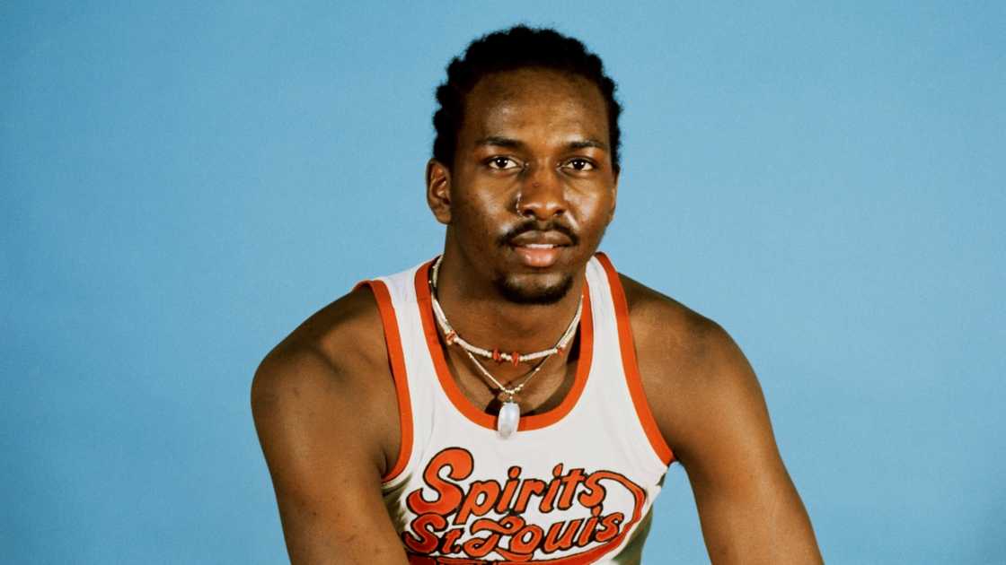 Moses Malone poses, sitting in a Spirits of St. Louis kit.