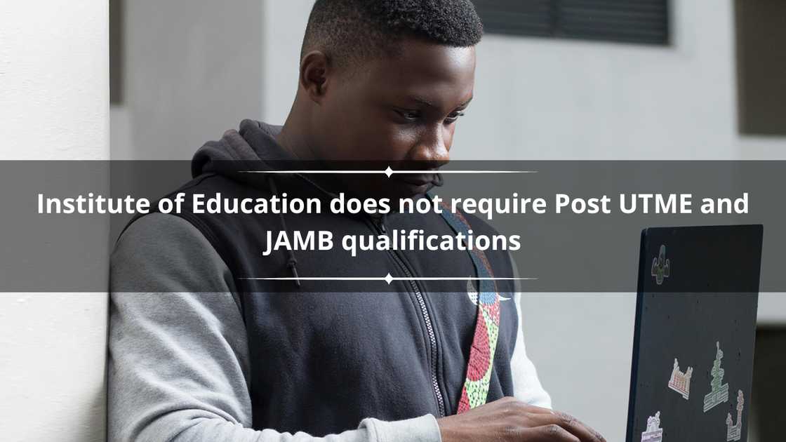 A young man using his laptop while standing