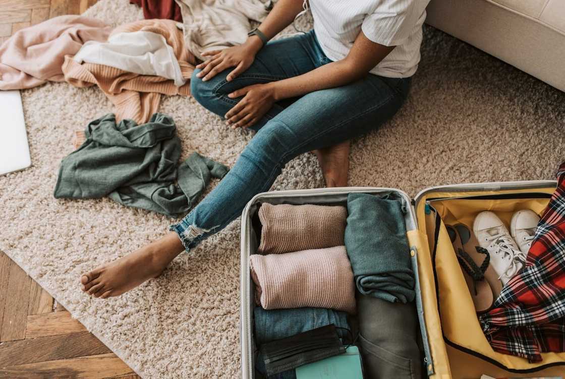 A woman packs her suitcase at home. A woman packs her suitcase at home.