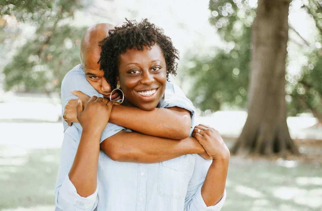 A man hugs a woman from behind