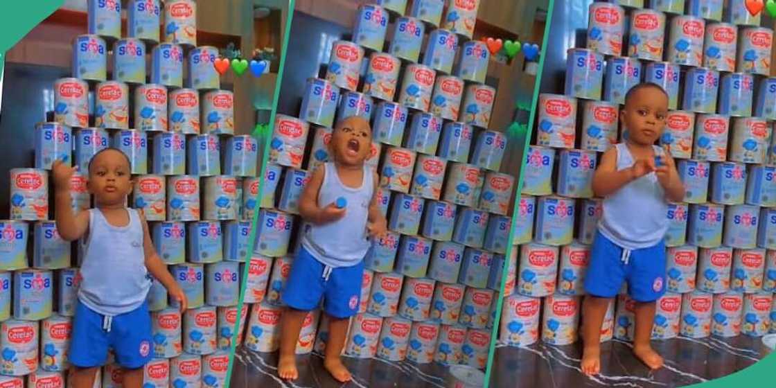 Little boy shows off empty cans of milk Little boy shows off empty cans of milk