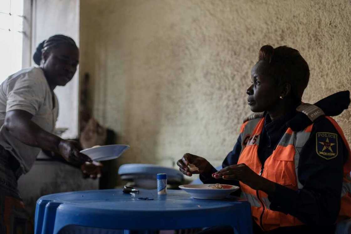 Shift over: Cecile Bakindo eats in a restaurant next to her checkpoint after directing traffic all morning