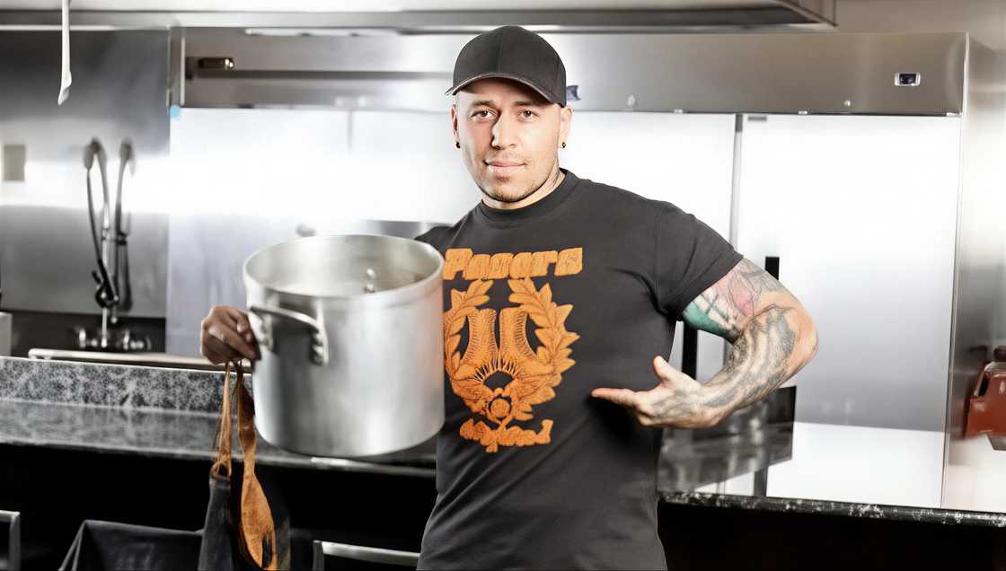 Chef Vic Vegas poses with a pot in a kitchen Chef Vic Vegas poses with a pot in a kitchen