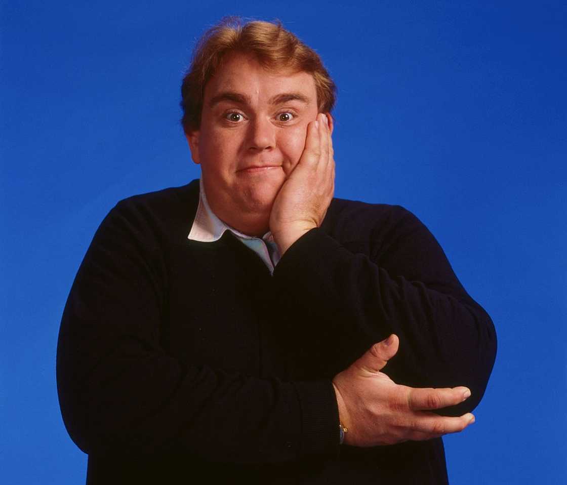 John Candy posing against a blue background