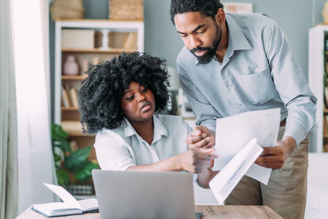 One partner shows papers to another partner.