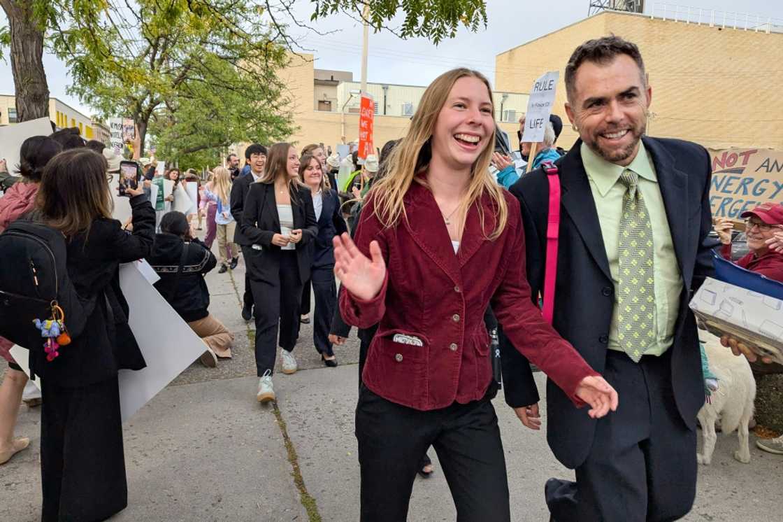 Eva Lighthiser (2R), lead plaintiff in the Lighthiser v. Trump case, walks with attorney Mat dos Santos as they arrive at the Russell Smith Courthouse in Missoula, Montana, on September 16, 2025