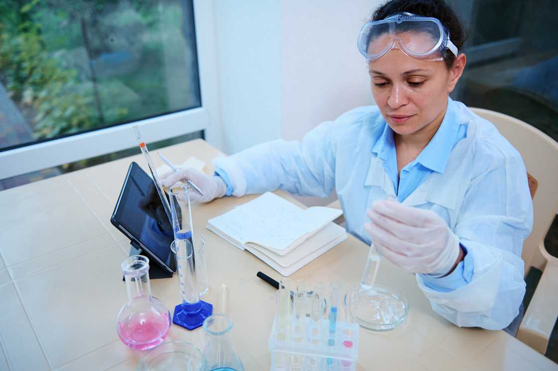 A female pharmacologist working on the development of a new medical drug. A female pharmacologist working on the development of a new medical drug.