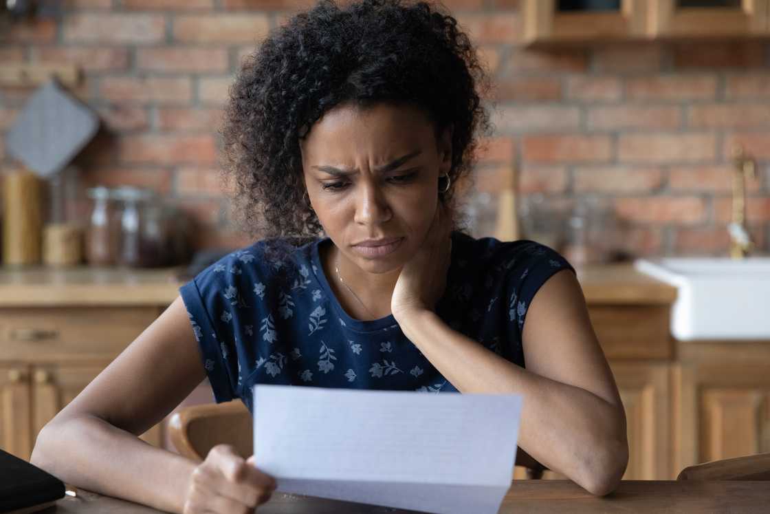 An unhappy woman reading a letter.