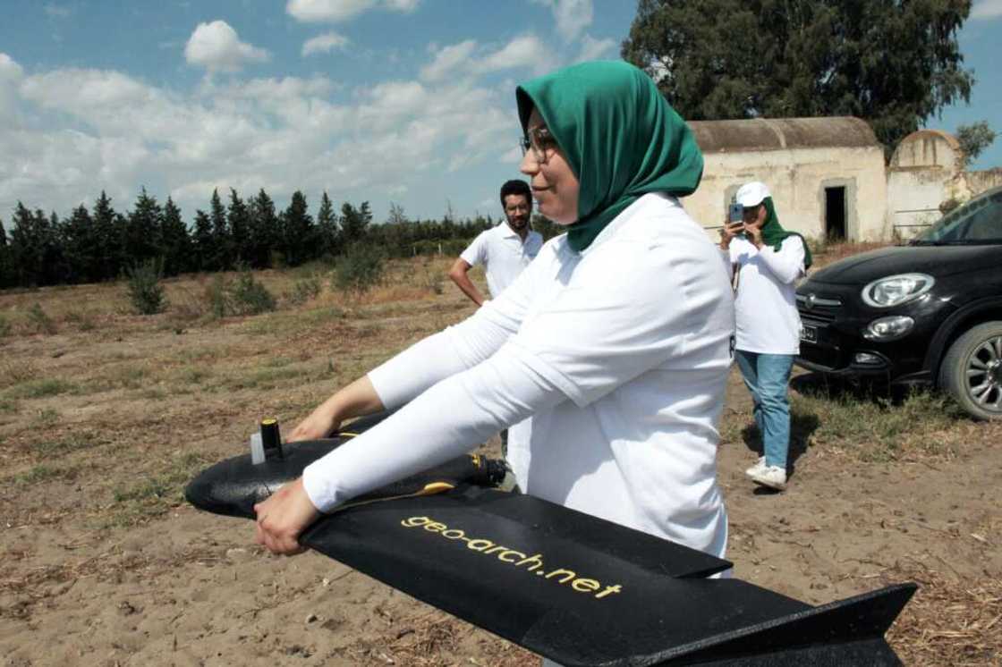 Imen Hibri, the founder of RoboCare, prepares to fly a drone over an agricultural area to scan the trees from the air