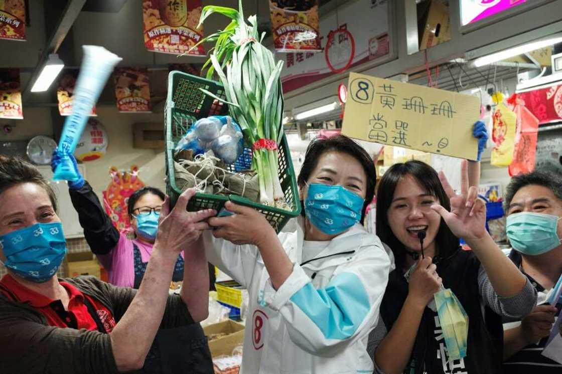 Taipei mayoral candidate Huang Shan-shan (C) holds aloft a basket of 'lucky vegetables' gifted by supporters Taipei mayoral candidate Huang Shan-shan (C) holds aloft a basket of 'lucky vegetables' gifted by supporters