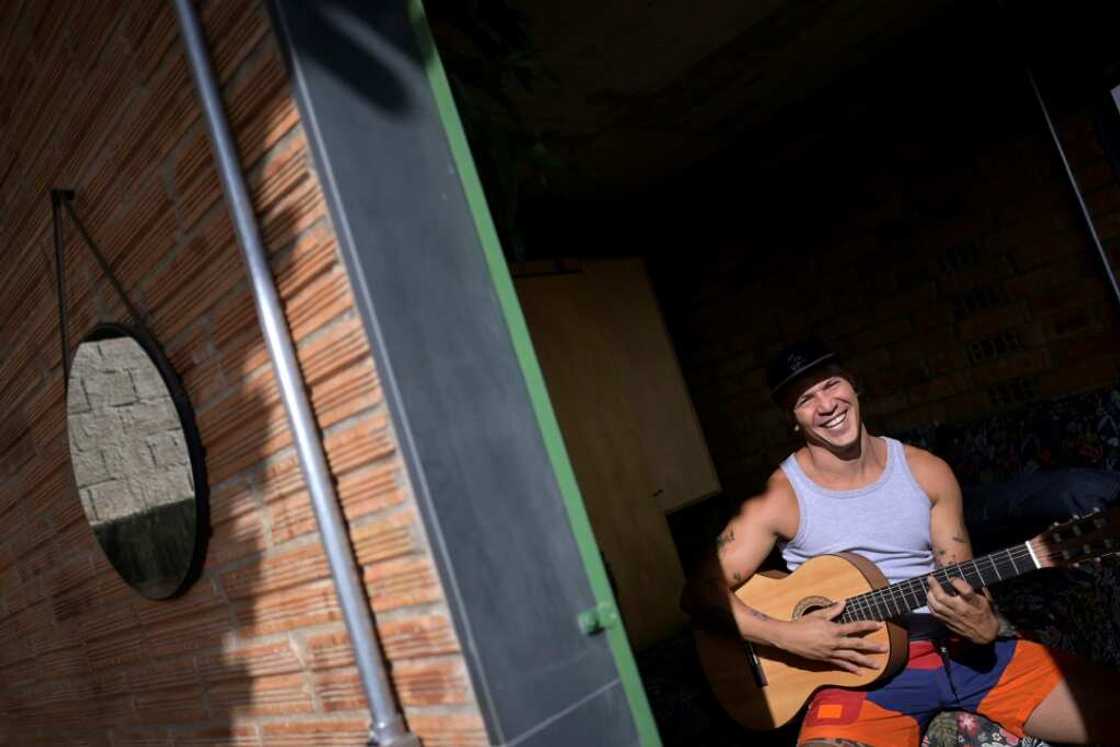 Brazilian artist Kdu dos Santos plays the guitar in his home in Belo Horizonte; the small house was recently declared "house of the year" by a specialized architecture website