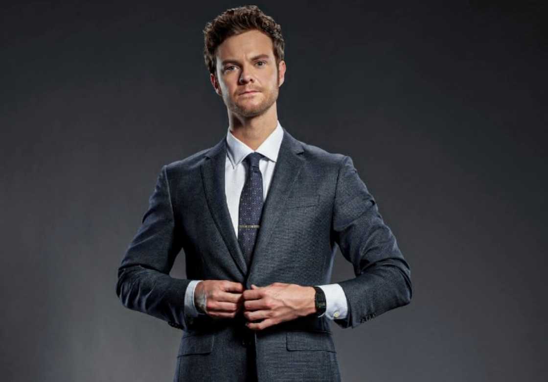 Jack Quaid poses in a suit as the character Hughie Campbell