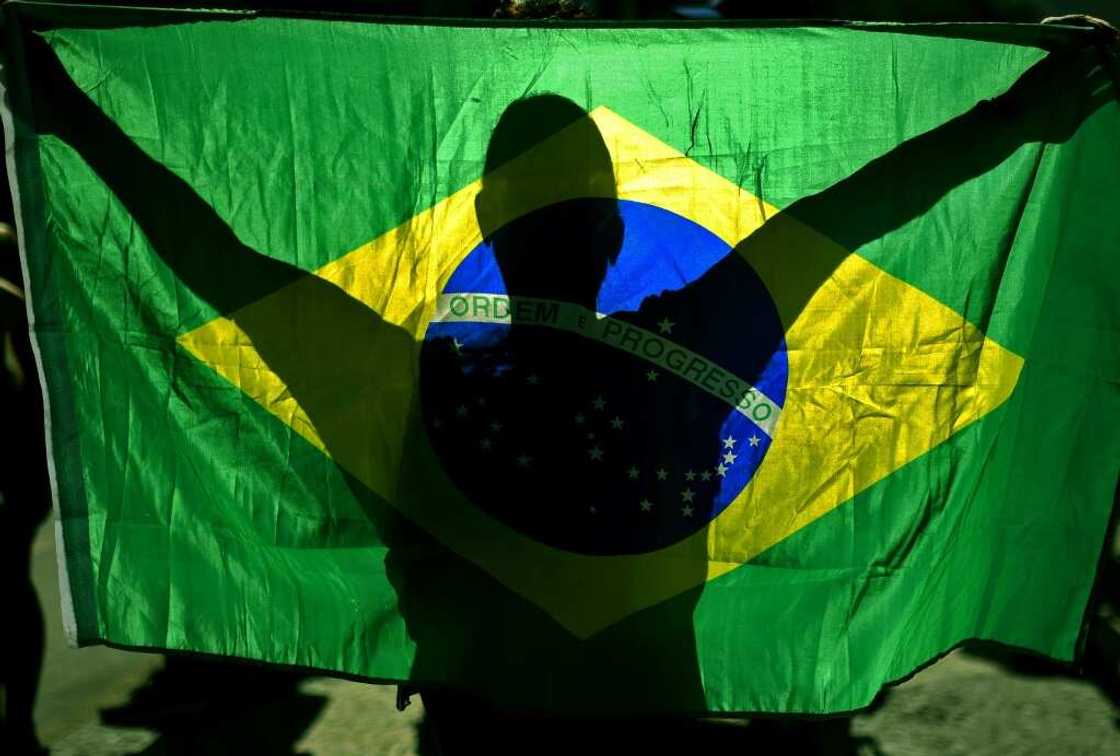 Supporters of Brazilian President Jair Bolsonaro embrace the national flag as a symbol of their support for him Supporters of Brazilian President Jair Bolsonaro embrace the national flag as a symbol of their support for him