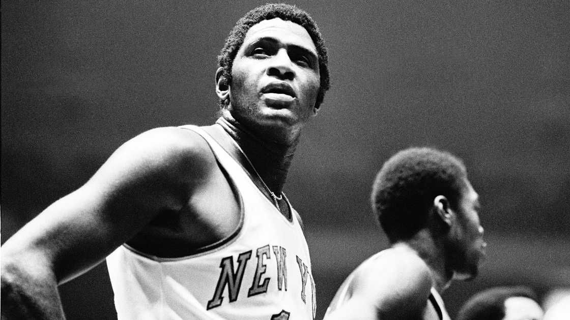 Willis Reed of the New York Knicks pauses to look at the scoreboard during a game.