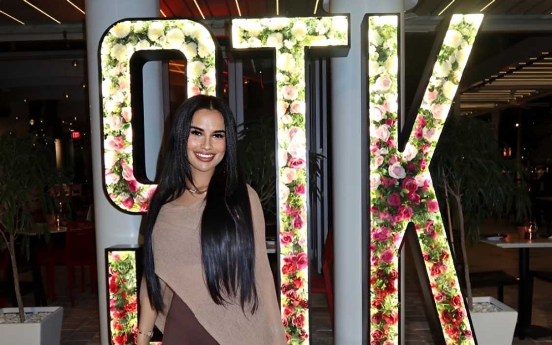 Yulissa Escobar poses in front of a floral STK sign
