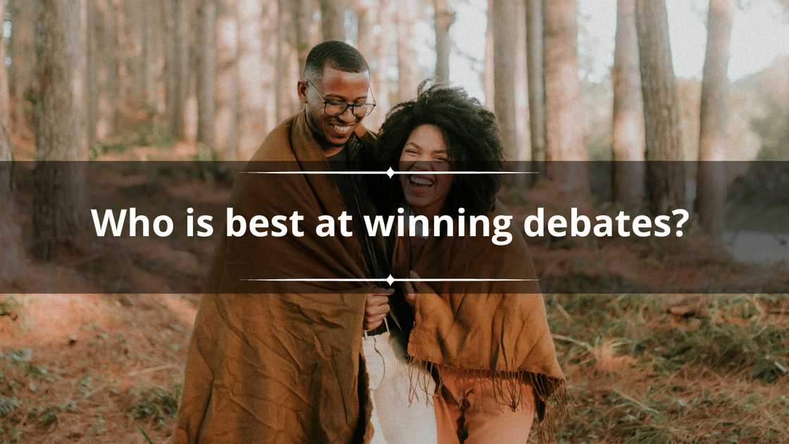 A happy couple is pictured sharing a brown blankie in the woods