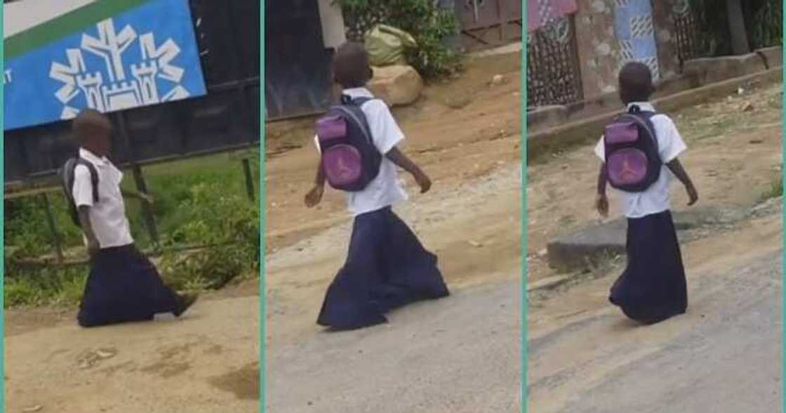 Primary school girl walks on the road in oversized uniform