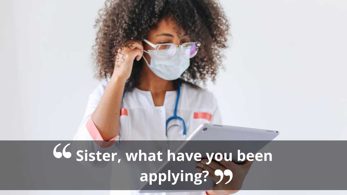 A healthcare worker wearing a mask and reading from a tablet.
