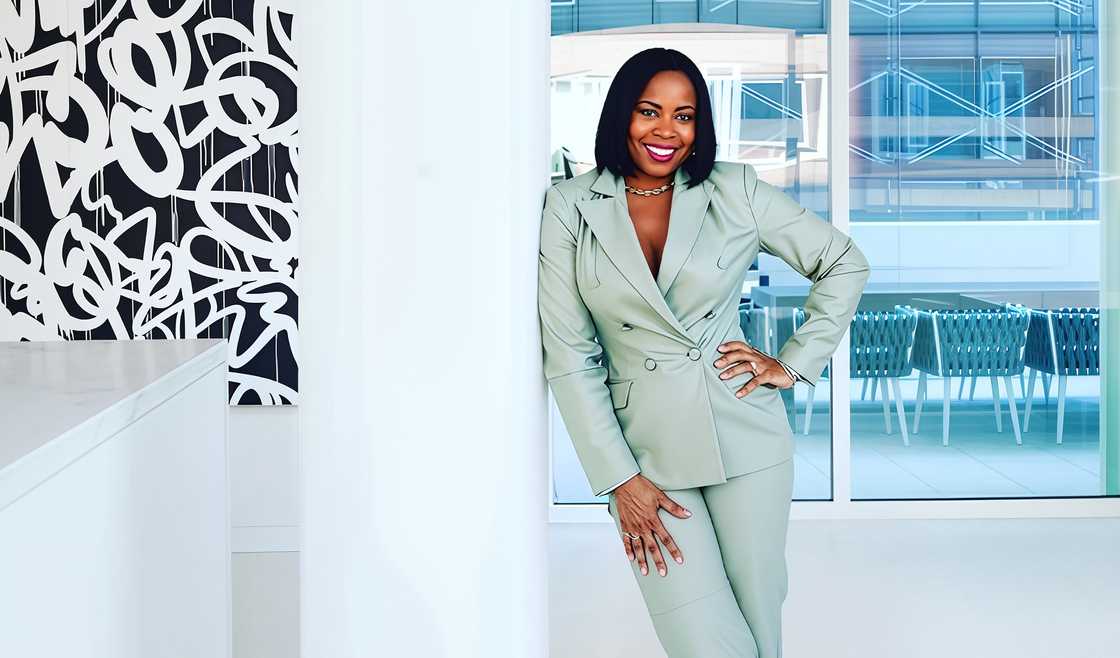 Tricia Lee leans on a pillar in a green suit. Tricia Lee leans on a pillar in a green suit.