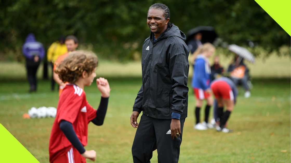 Nwankwo Kanu playing with a kid at a FIFA event in London.