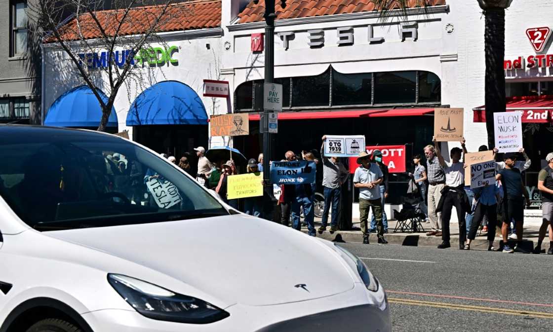 People participate in a protest against Elon Musk outside a Tesla dealership in Pasadena, California on March 8, 2025