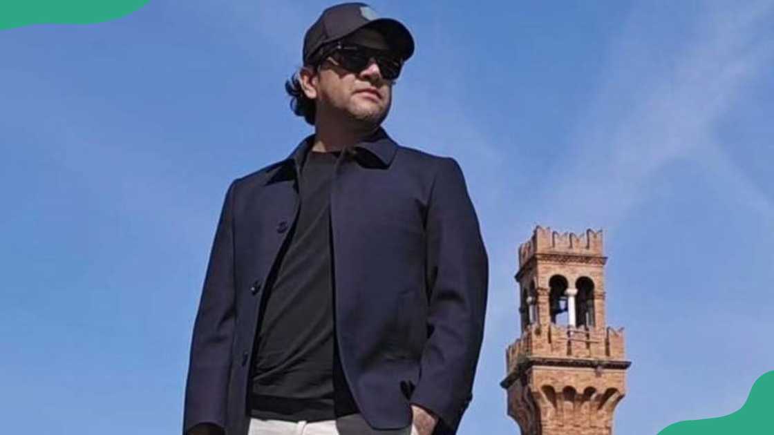 Sebastian Grey stands next to a tower Sebastian Grey stands next to a tower
